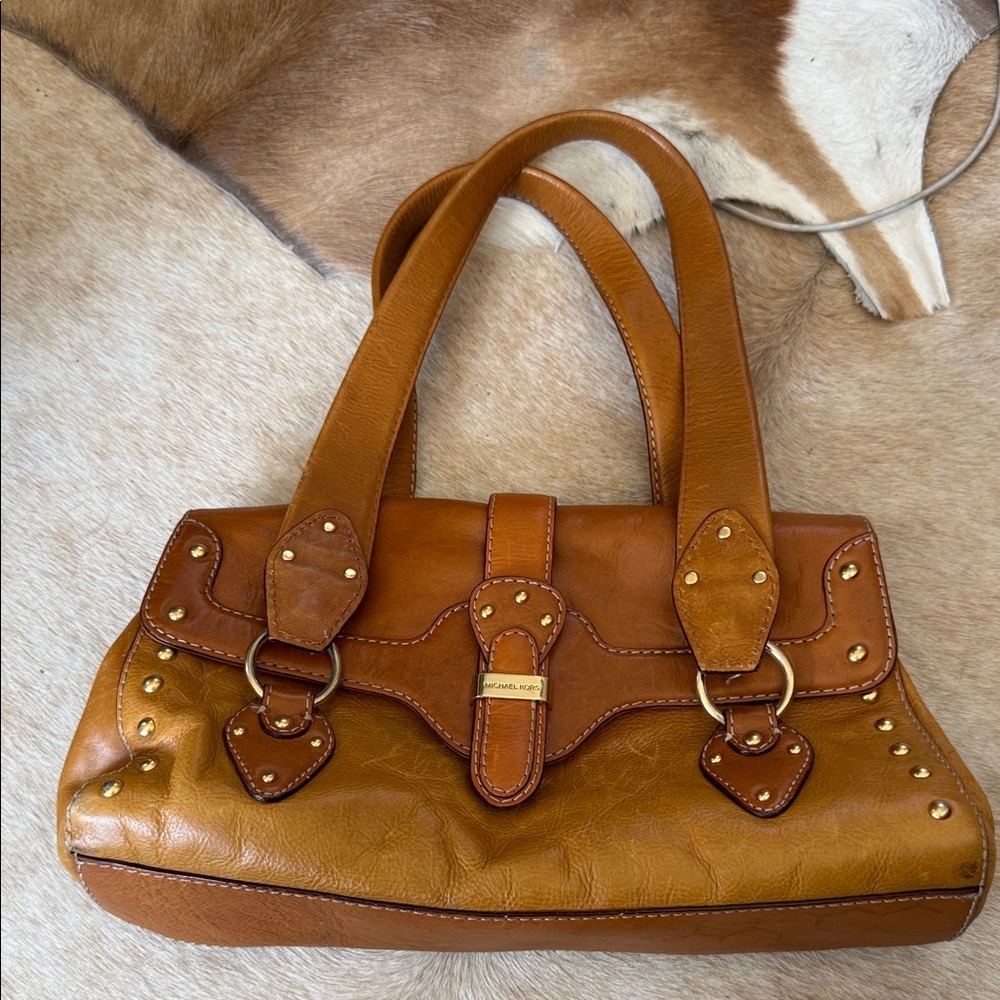 This is a vintage Michael Kors brown leather shoulder bag featuring gold studs